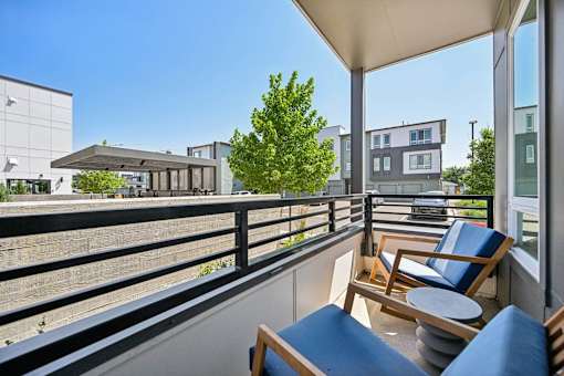 Private balcony with seating and courtyard views at Sequel Homes Apartments, Englewood, CO 80110