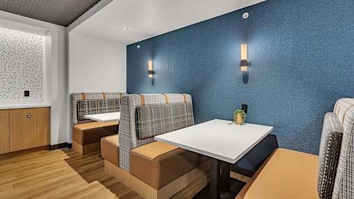 Dining area with booth seating and blue accent wall at Grand Gateway Apartments, St Cloud, MN