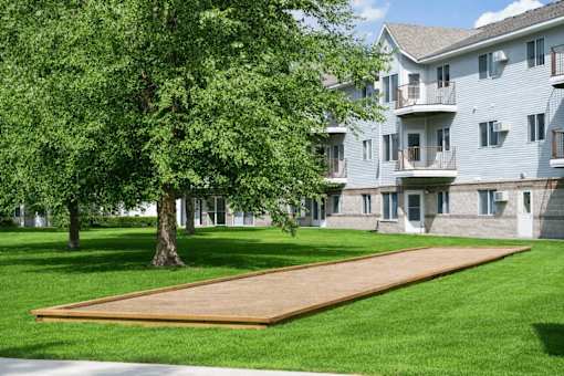 Outdoor shuffleboard court with manicured lawn and trees at Regency Park Apartments, Minnesota, 56304