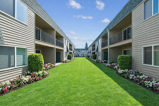 A long row of apartment buildings with green lawns in between.