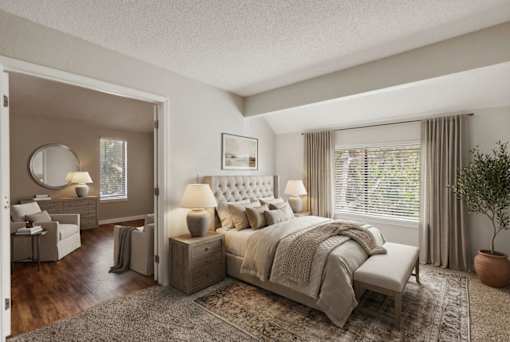 A bedroom with a large bed and a dressing table with a mirror.