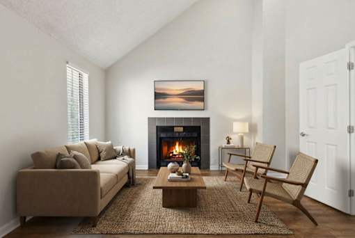 A cozy living room with a fireplace and a painting on the wall.