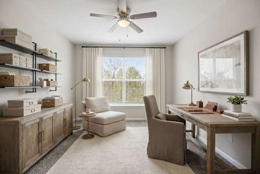 A room with a table, chairs, and a ceiling fan.