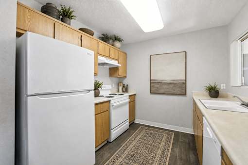 A kitchen with a white refrigerator and wooden cabinets.