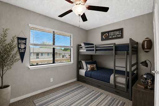 A room with a bunk bed and a ceiling fan.