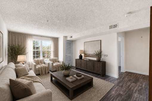 A living room with a couch, a coffee table, and a large window.