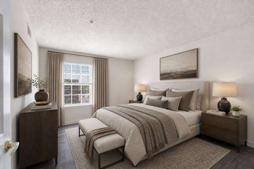 A bedroom with a large bed, a nightstand, and a window with curtains.