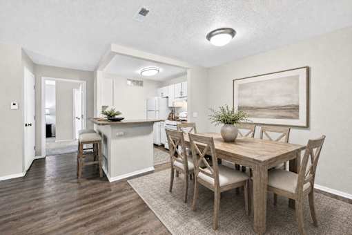 A dining room with a wooden table and chairs.