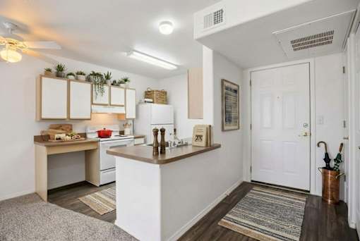 A kitchen with white walls and a white door.