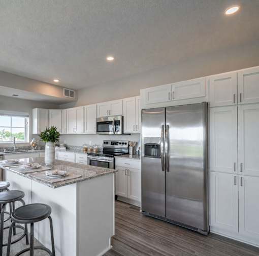 Modern kitchen with white cabinetry and granite countertops at The Hendrickson Apartments, Minnesota, 55113