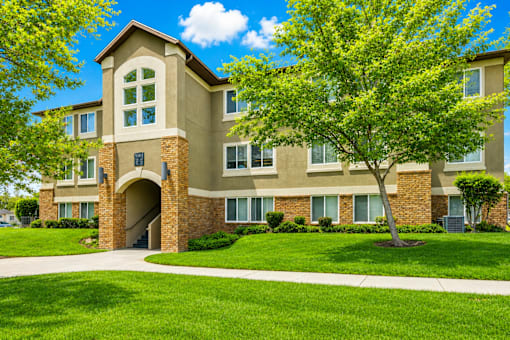 A large building with a tree in front of it at Slate Canyon Apartments, Utah