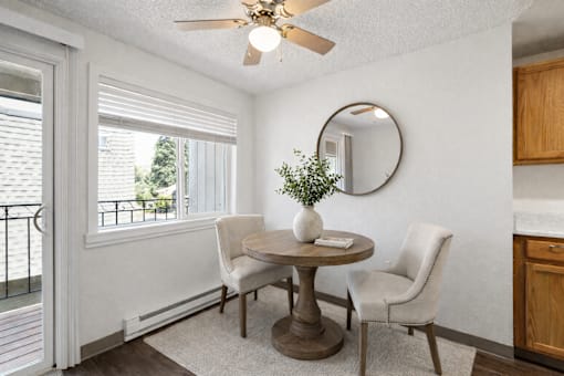 A dining room with a table and chairs.