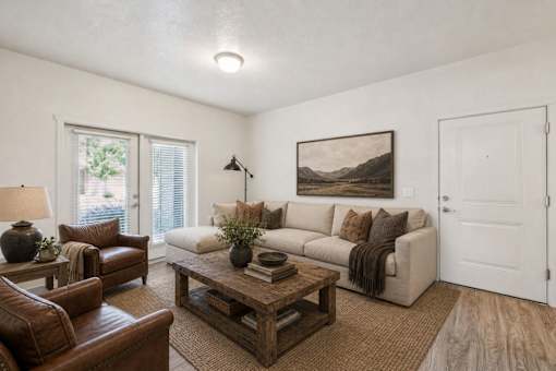Living room with beige sofa and brown leather chairs at Silver Ridge Apartments, Idaho, 83642