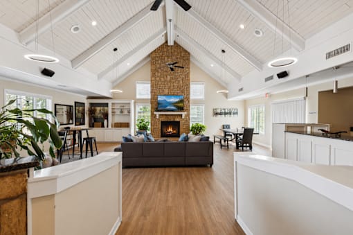 A spacious living room with a fireplace and a grey couch.