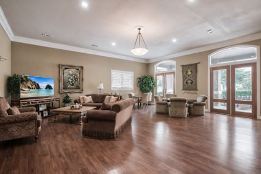 A spacious living room with wooden floors and furniture.