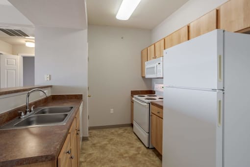 a kitchen with a sink and a refrigerator at Stetson Meadows Apartments, Colorado Springs