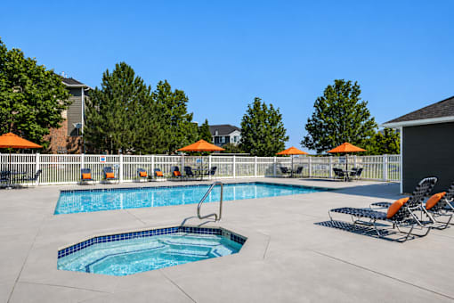 A swimming pool with a slide and sun umbrellas at Haven Pointe Apartments, West Haven, Utah