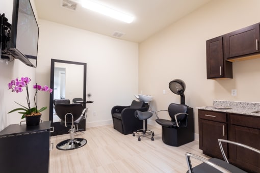 a salon room with two chairs and a sink