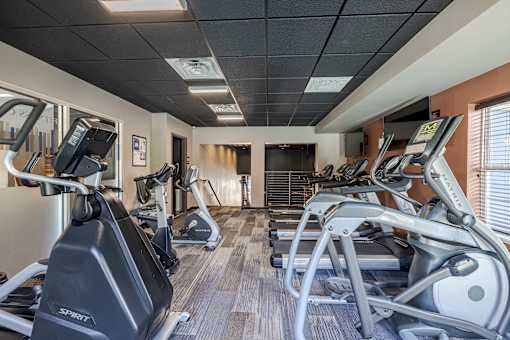 A gym with treadmills and elliptical machines.