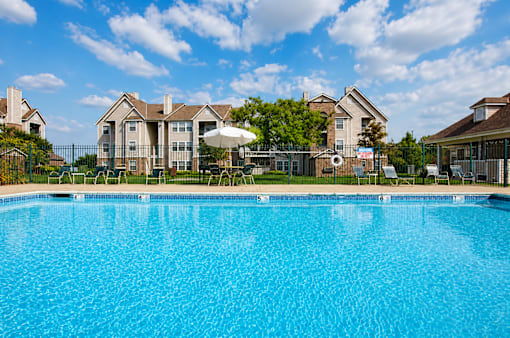 A large swimming pool in front of a residential area.