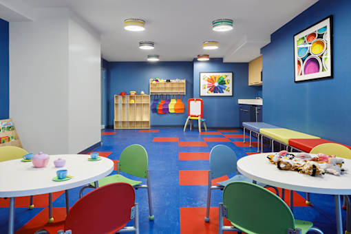A colorful children's playroom with tables and chairs.