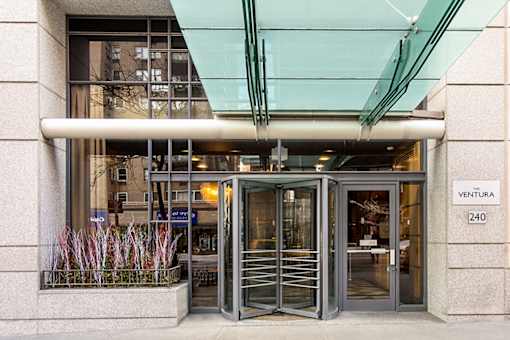 The entrance to a building with a glass canopy and a sign that reads "VENTURA 240".