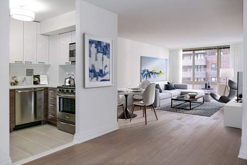 A modern kitchen with a dining area and a painting on the wall.