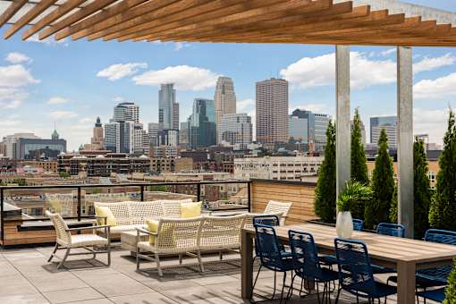 A patio with chairs and a table overlooking a city skyline.