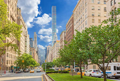 A city street with a tall blue building in the background.