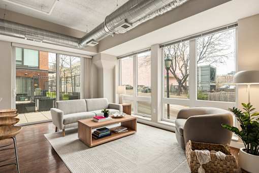 A living room with a grey sofa, a wooden coffee table, and a chair.