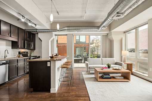 A modern kitchen with dark wood floors and a large island.