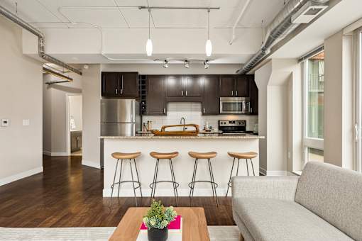 A kitchen with dark brown cabinets and a white countertop.