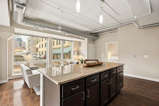 A kitchen with a marble countertop and black cabinets.