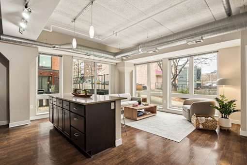 A modern kitchen with dark wood floors and a large island.