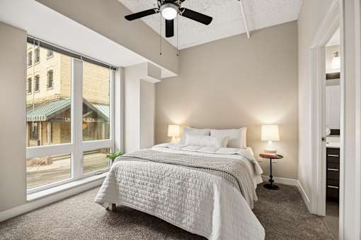 A bedroom with a large bed and a ceiling fan.