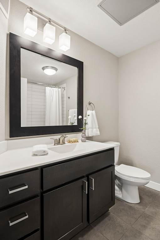 A bathroom with a white countertop and a white toilet.