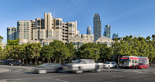 Cars are driving on a road in a city.