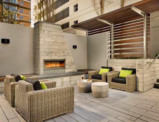 A patio with a fireplace and wicker chairs.