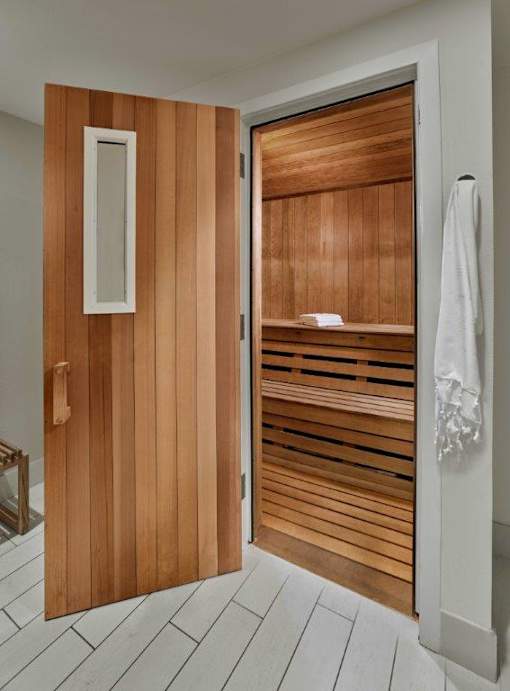 A wooden door with a white handle and a towel hanging on the wall.