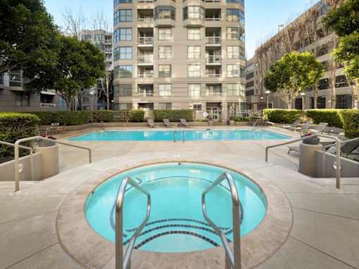 A small pool in a courtyard surrounded by buildings.