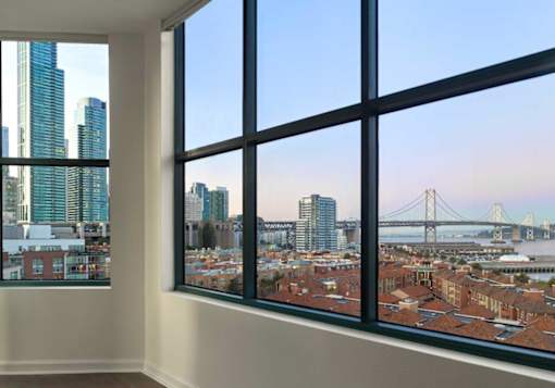 A room with a large window overlooking a cityscape.