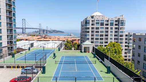 A tennis court is located on the roof of a building.