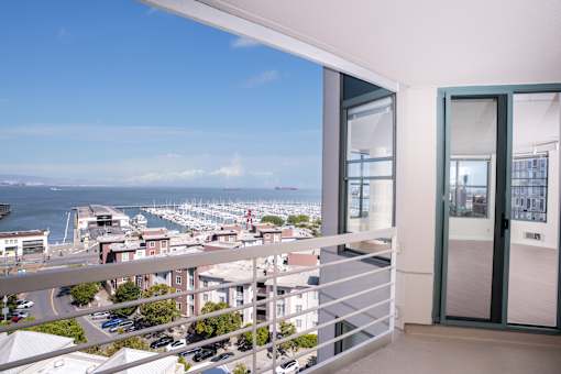 A balcony with a view of a harbor and buildings.