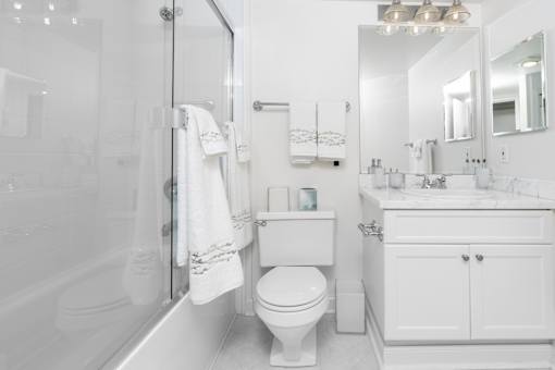A white bathroom with a toilet, sink, and bathtub.