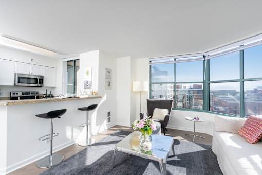 A modern living room with a bar area and a view of the city.