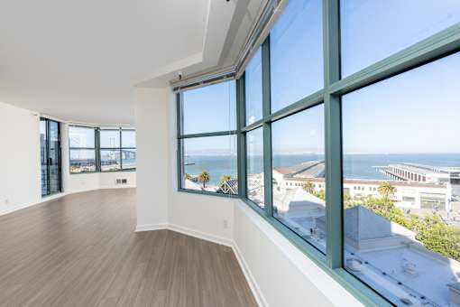 A room with a view of the ocean through large windows.