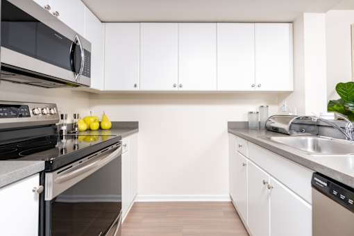 A kitchen with white cabinets and a stainless steel oven.