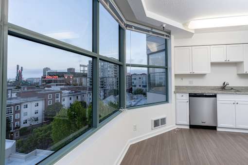 A kitchen with a large window overlooking a cityscape.