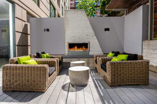 A patio with a fireplace and wicker chairs.