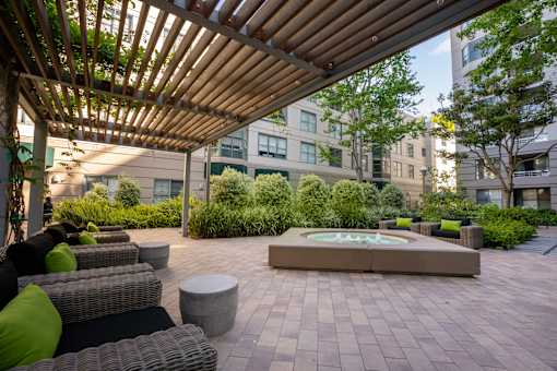 A patio with a fountain and a pergola.